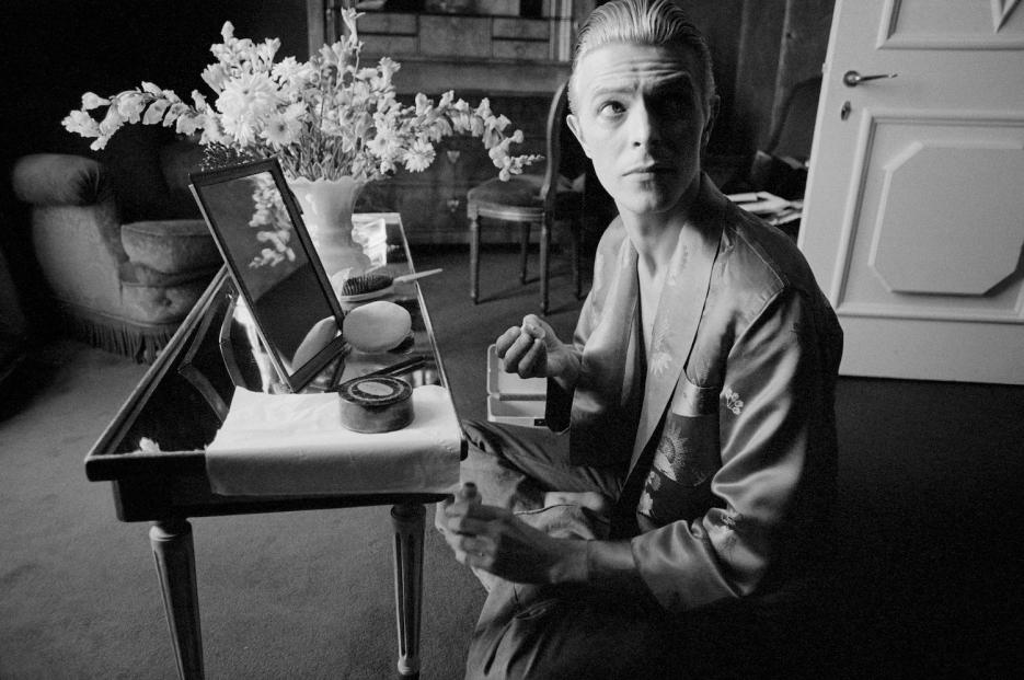 David prepares his makeup in his hotel suite prior to an impromptu photo shoot that morning in Paris, 1976